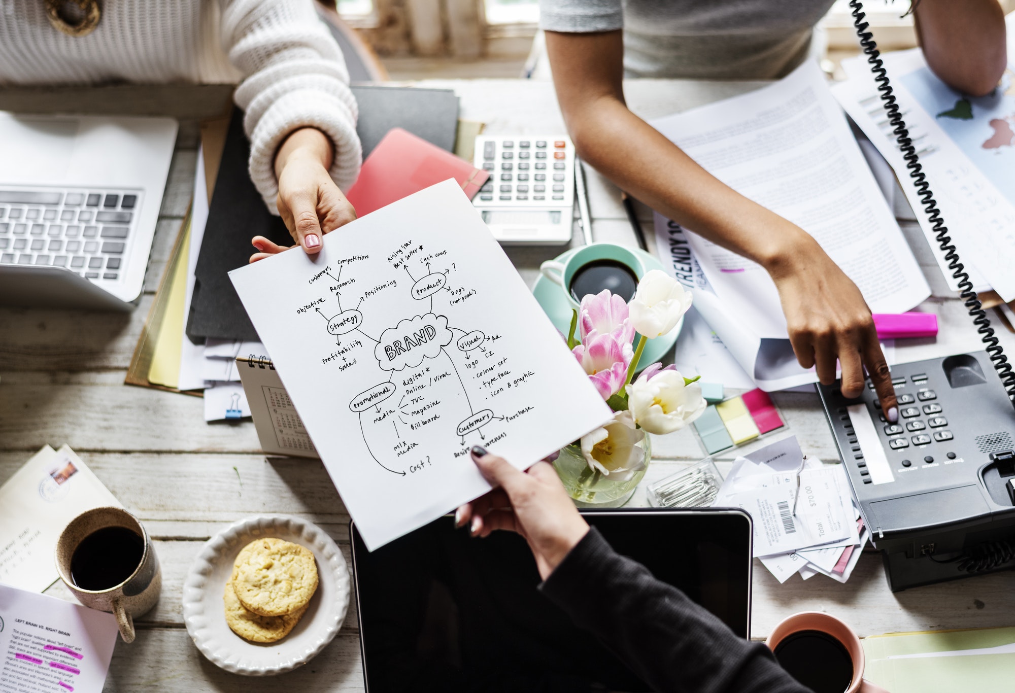 colleagues handing branding plan strategy to other jpg